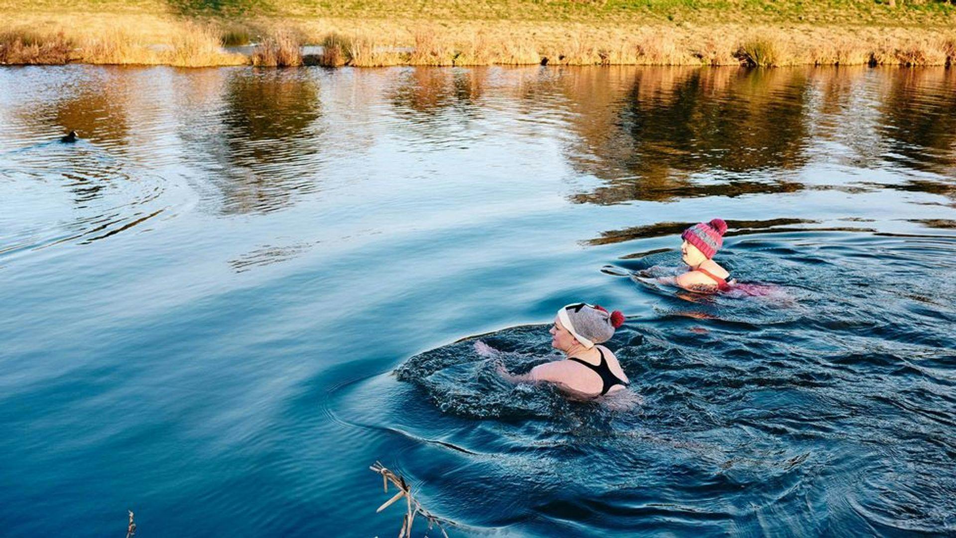 wild swimmers in hat in lake