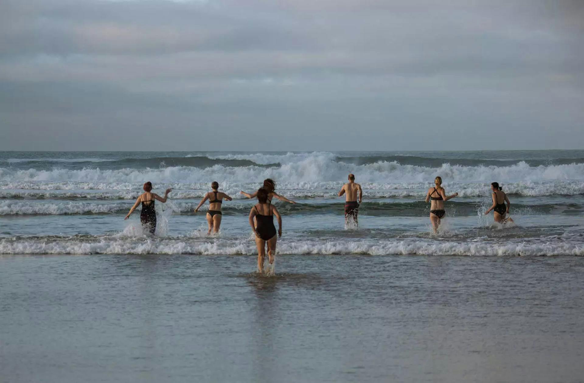 women running into the sea