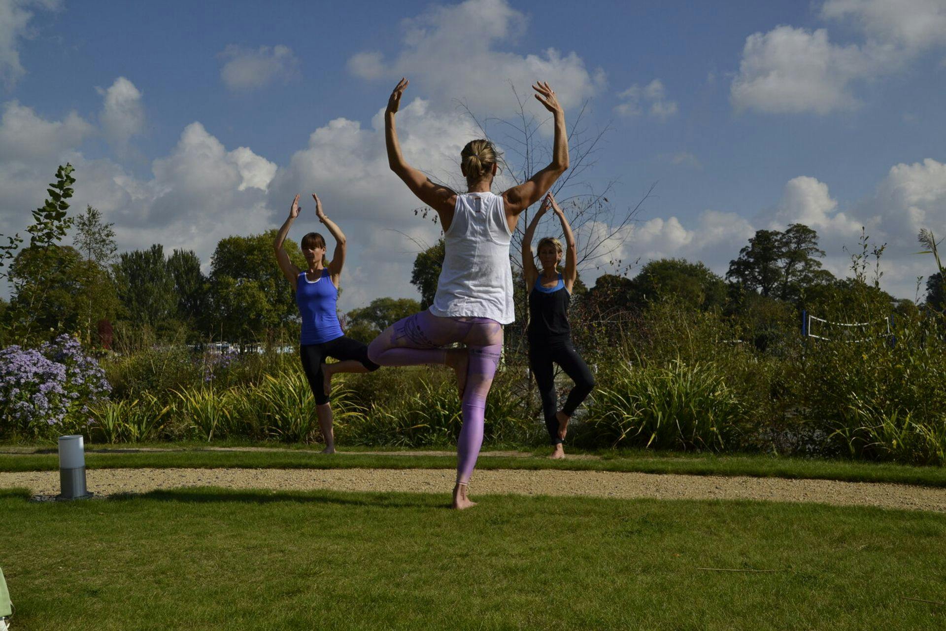 women practising yoga on the grass